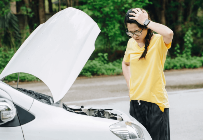 Woman checking broken down car