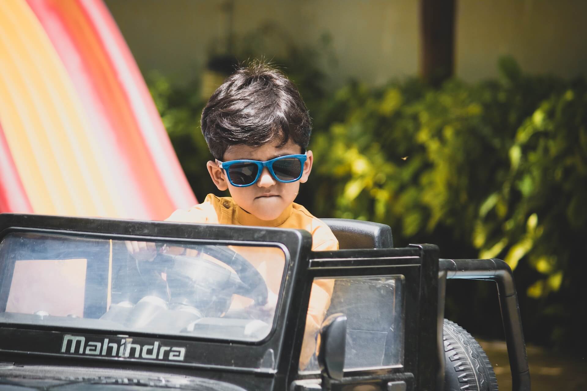 little boy wearing sunglasses driving toy car, keselamatan kanak-kanak