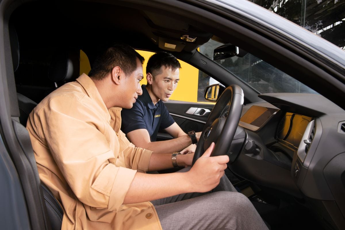 CARSOME Consultant in car explaining to customer