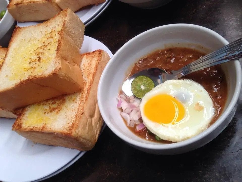 A bowl of Kacang Pool and a plate of fluffy pieces of toast