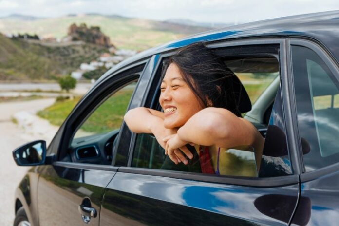 Woman on a road trip looking out of the car window
