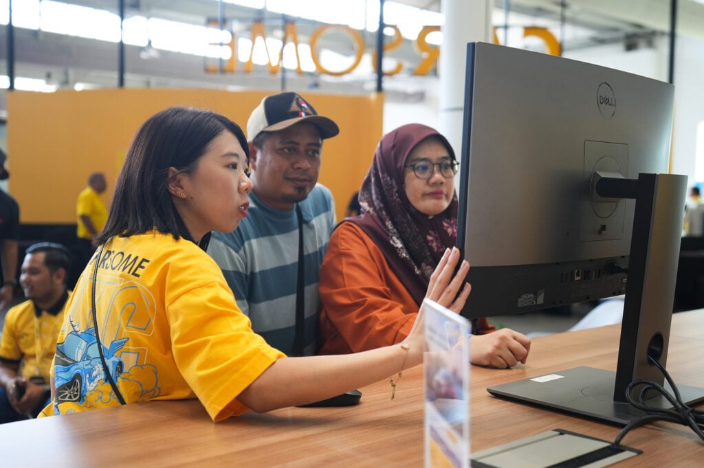 CARSOME staff showing cars to customers inside showroom during CARSOME’s 10th Year Anniversary Autofair celebration
