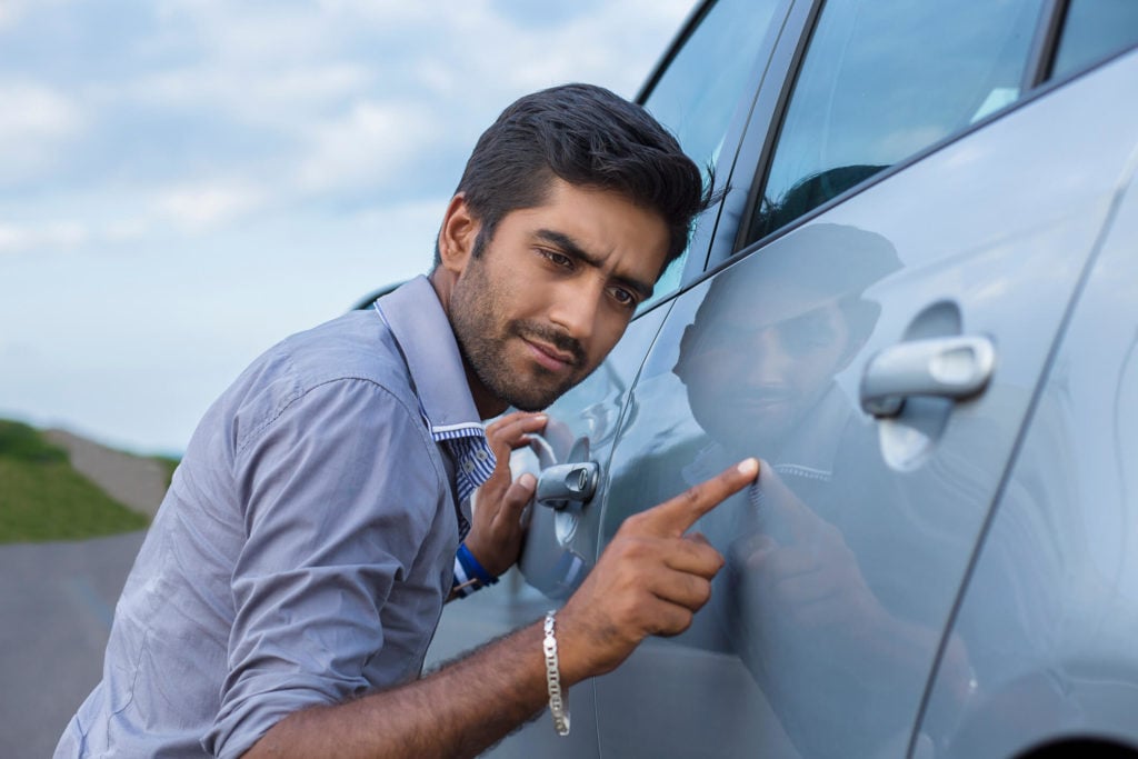 man inspecting a car